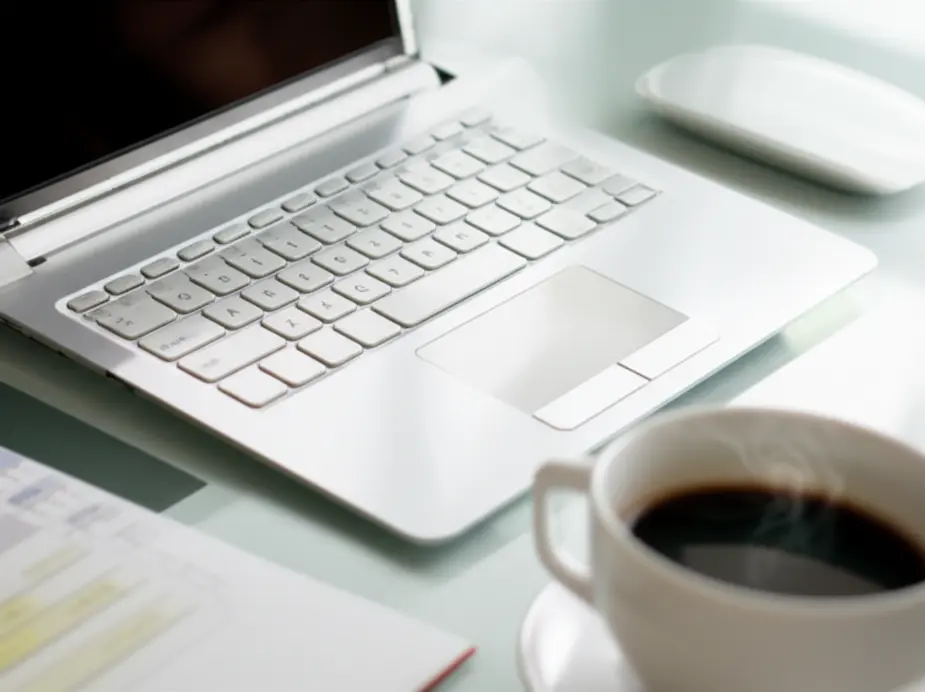 Ambiente de trabalho remoto com laptop e calendário.
