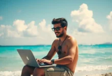 Nômade digital, sentado em uma praia, trabalhando em seu laptop.
