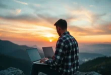 Nômade digital trabalhando em um laptop em uma montanha ao pôr do sol.