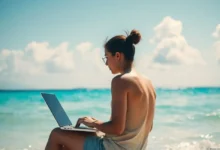 Pessoa trabalhando em um laptop em uma praia, simbolizando a liberdade dos nômades digitais.