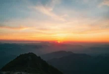 Pôr do sol no topo da montanha simbolizando crescimento sustentável