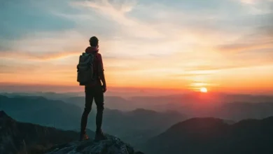 Nômade digital no topo da montanha admirando um pôr do sol.