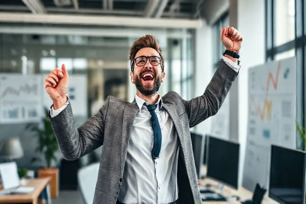 7 Estratégias para Aumentar a Lucro da Sua Empresa em 2024 - Web Nômade Digital Empreendedor vibrando de felicidade no escritório após alcançar metas financeiras.