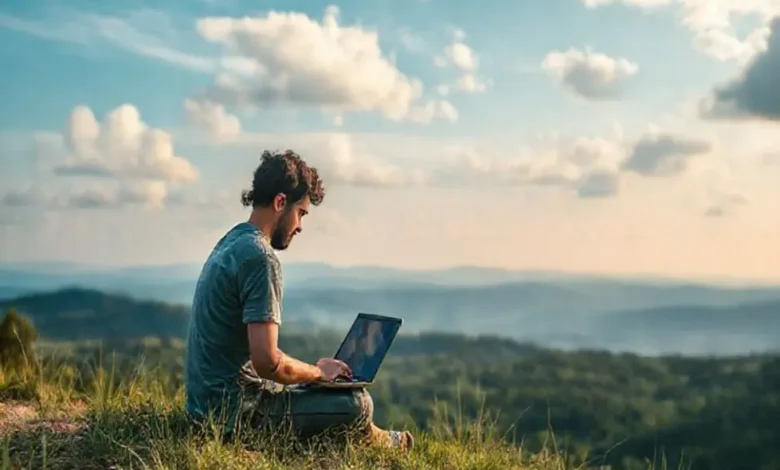 Nômade digital utilizando um laptop em um ambiente natural tranquilo.