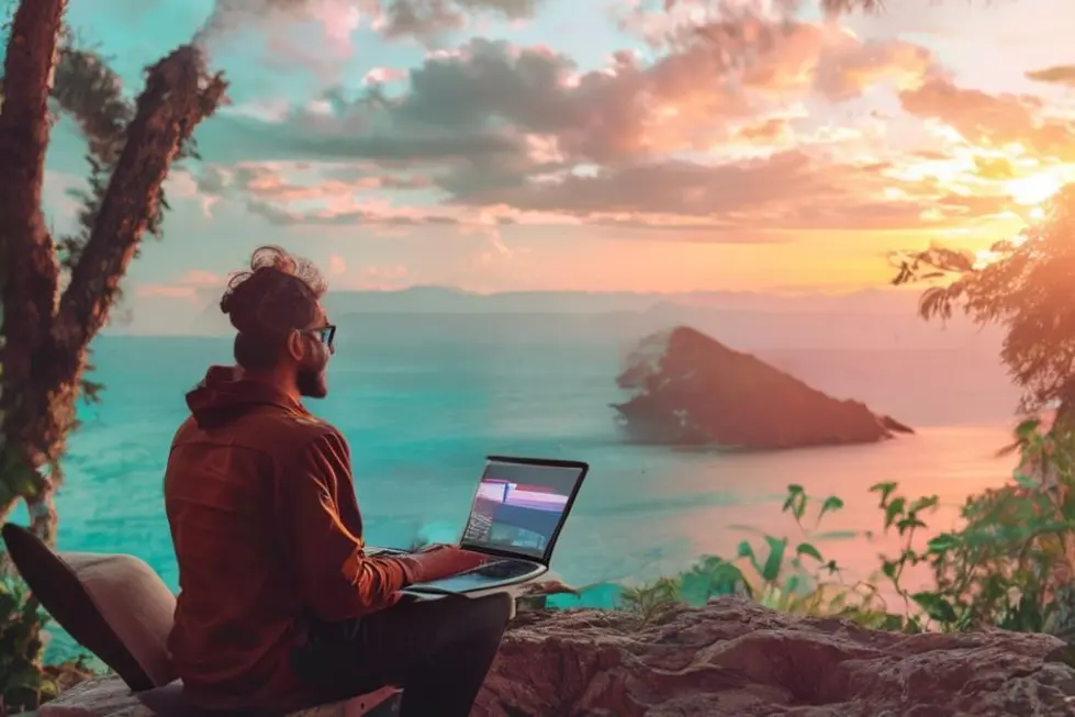 Um nômade digital em um local bonito, usando um laptop.