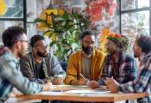 Grupo diversificado de mentorados e mentor discutindo ideias em um ambiente criativo.