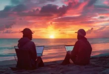 Um nômade digital utilizando um laptop na praia ao pôr do sol.