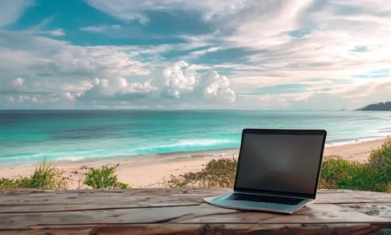 Laptop aberto em uma mesa de madeira, olhando para uma praia, simbolizando a liberdade do empreendedorismo digital.