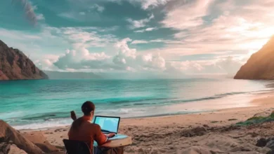 7 Estratégias Poderosas para Escalar seu Negócio Online em 2025 - Web Nômade Digital Nômade digital utilizando um laptop em uma praia, simbolizando liberdade e empreendedorismo.