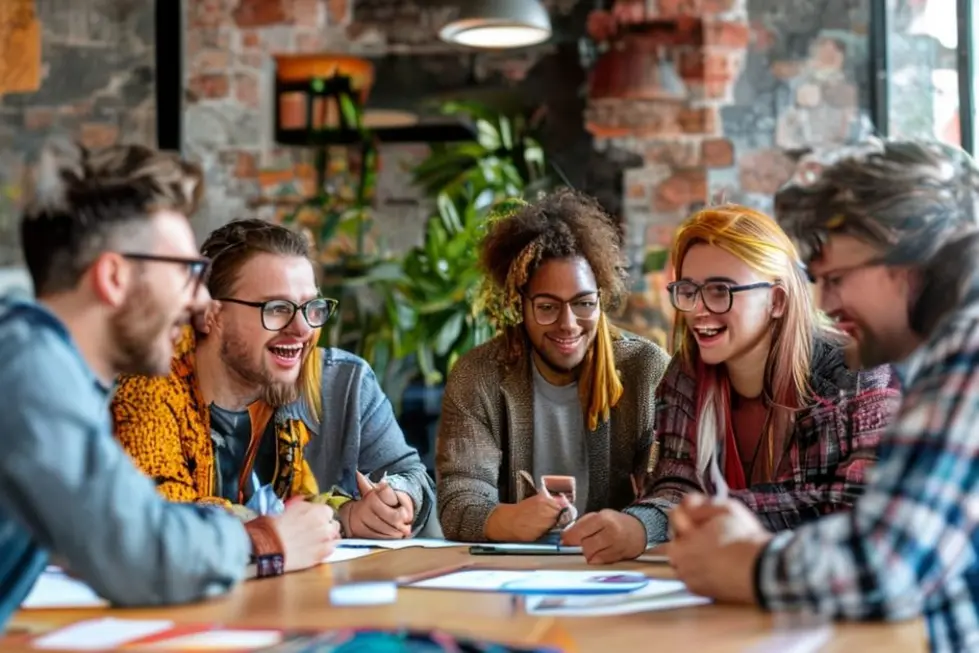 Grupo diverso de aspirantes a empreendedores discutindo ideias em uma mesa.