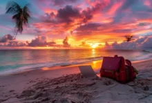 Um pôr do sol deslumbrante sobre uma praia, com um laptop e uma mochila simbolizando o estilo de vida de um nômade digital.