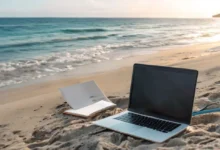 Cenário praiano com laptop e bloco de notas, representando nômades digitais.