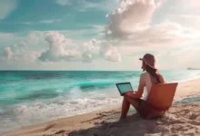 Nômade digital operando laptop na praia.