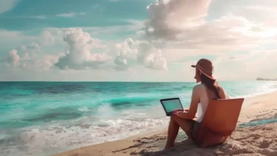 Nômade digital operando laptop na praia.