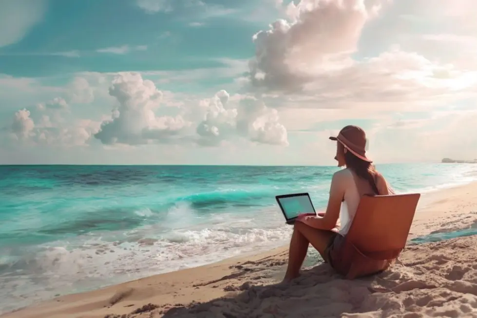 Nômade digital operando laptop na praia.