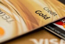 Stack of various branded credit cards focusing on gold card showing finance and cashless concept.