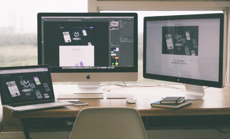 Stylish and efficient workspace with multiple monitors, laptop, and smartphone, showcasing a web design project.