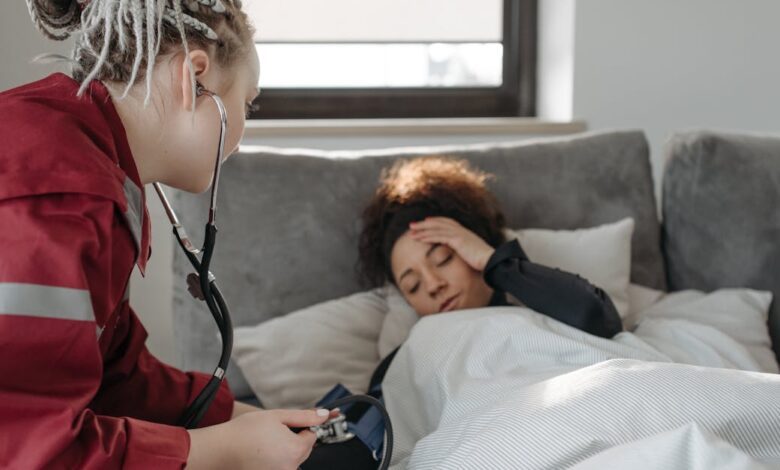 Como Viajar e Trabalhar em Cruzeiros: Dicas para Nômades - Web Nômade Digital A paramedic examines a sick woman with a stethoscope indoors, providing medical care.