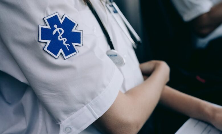 Paramedics in uniform work with medical charts inside an ambulance.