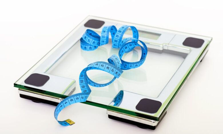 Como Manter a Saúde Mental Enquanto Viaja: Dicas Práticas - Web Nômade Digital A digital glass weighing scale with a blue measuring tape, symbolizing weight management.