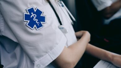 Paramedics in uniform work with medical charts inside an ambulance.