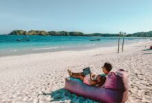 a man sitting on a bean bag on the beach