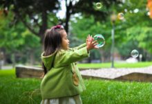 selective photo of a girl holding bubbles