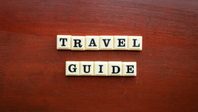 the word travel guide spelled with scrabble tiles