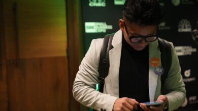 a man wearing glasses looking at his cell phone