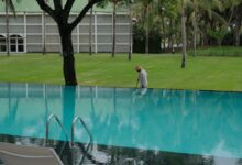 A person cleaning the edge of an infinity pool.