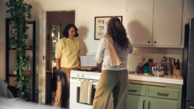 Two women talking in a kitchen while cooking