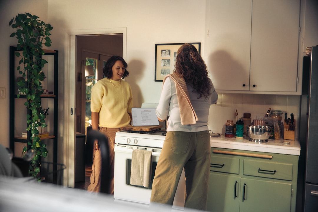 Two women talking in a kitchen while cooking