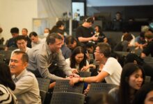 People gathered in a room, some interacting.