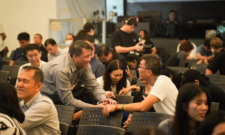 People gathered in a room, some interacting.