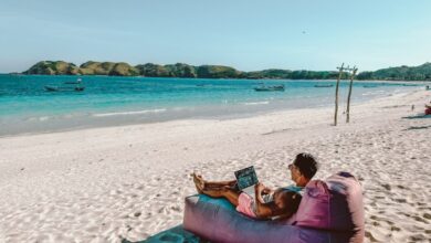 a man sitting on a bean bag on the beach