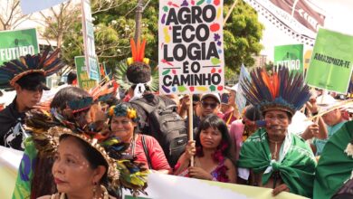 Indigenous people in traditional headdresses at a rally.
