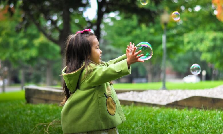 selective photo of a girl holding bubbles