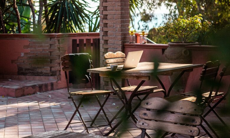 Outdoor patio table with chairs and laptop