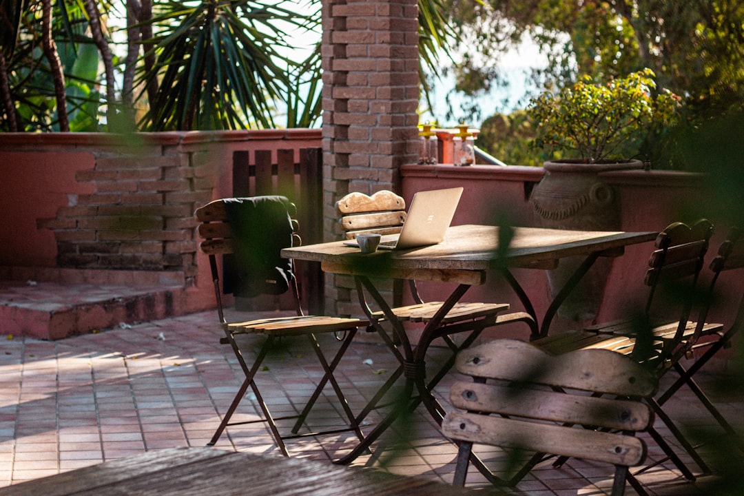 Outdoor patio table with chairs and laptop