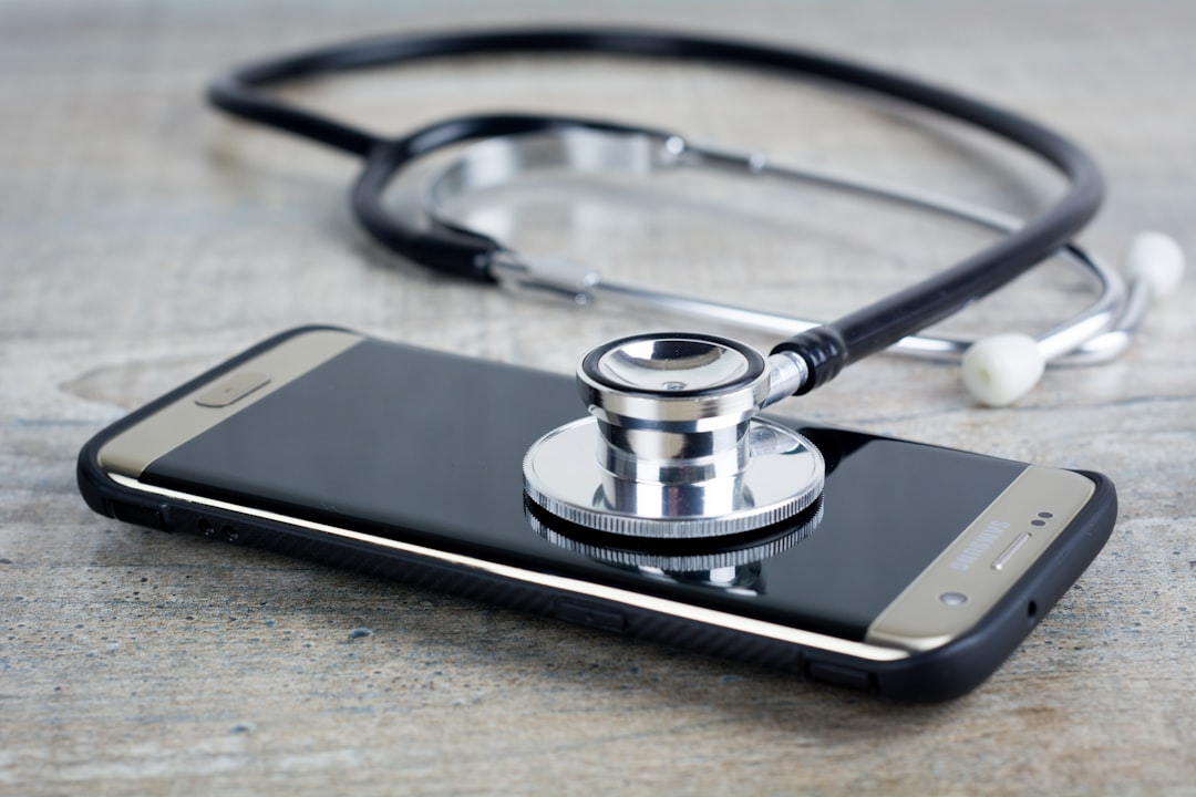 Os Melhores Aplicativos de Telemedicina para Nômades Digitais - Web Nômade Digital a smart phone with a stethoscope on top of it