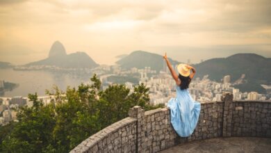 Como Viajar e Trabalhar com Segurança em Destinos Exóticos - Web Nômade Digital a woman standing on top of a stone wall