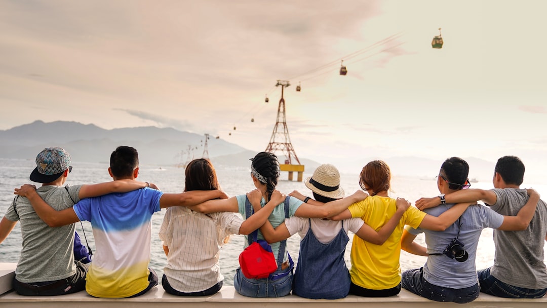 Como Fazer Networking Eficiente em Viagens de Trabalho - Web Nômade Digital people holding shoulders sitting on wall