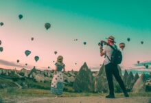 man taking photo of hot air balloons