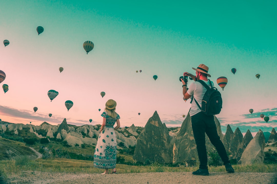 Como Viajar e Trabalhar em Destinos de Eco-Turismo Sustentável - Web Nômade Digital man taking photo of hot air balloons