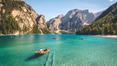 three brown wooden boat on blue lake water taken at daytime