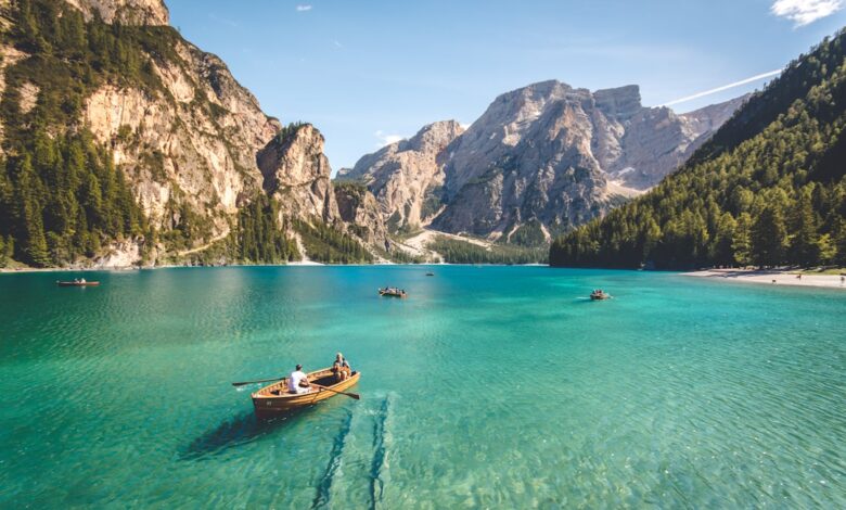 three brown wooden boat on blue lake water taken at daytime