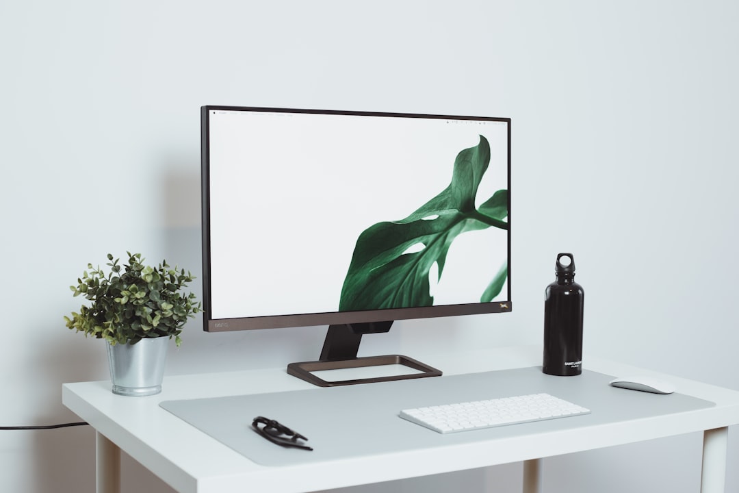 Como Criar um Setup Minimalista para Trabalhar em Qualquer Lugar - Web Nômade Digital a computer monitor sitting on top of a white desk