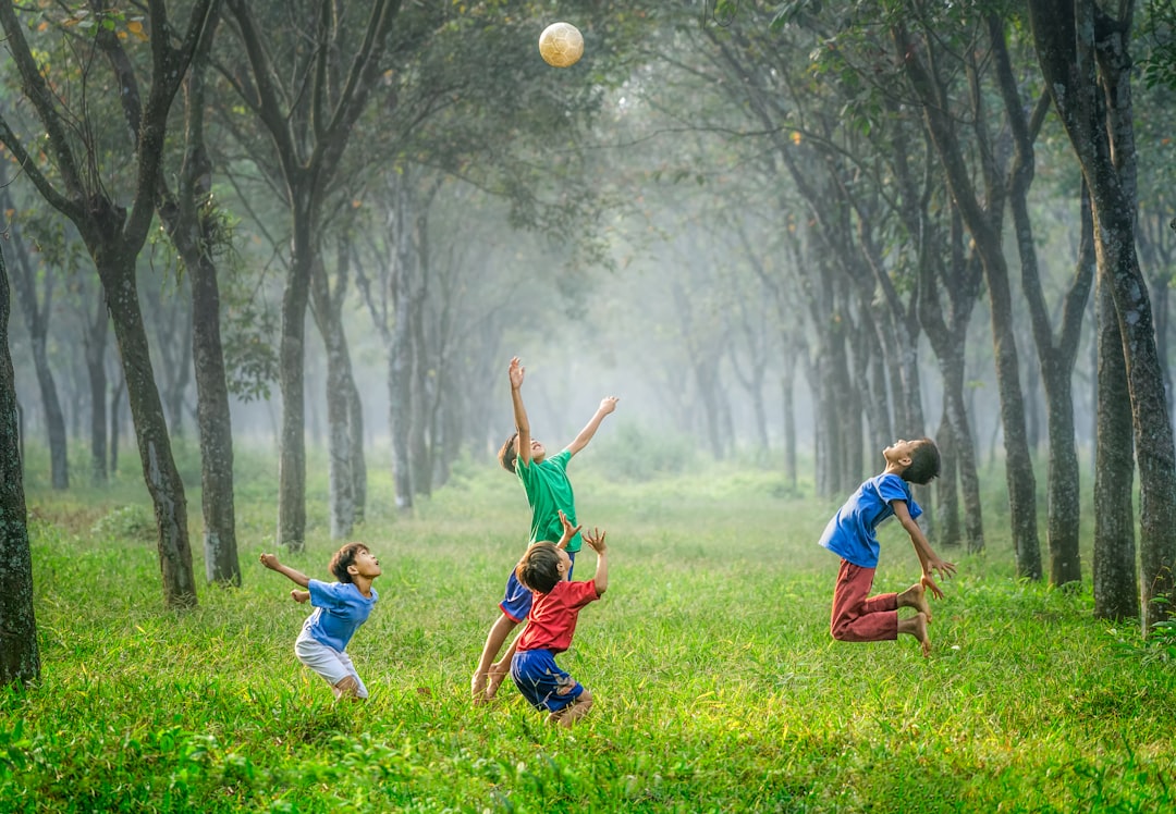 Como Viajar com Crianças: Dicas para Nômades Digitais - Web Nômade Digital four boy playing ball on green grass