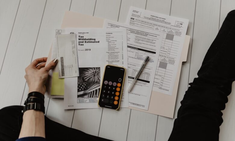 Como Criar uma Renda Passiva com Crowdfunding para Nômades - Web Nômade Digital person holding paper near pen and calculator