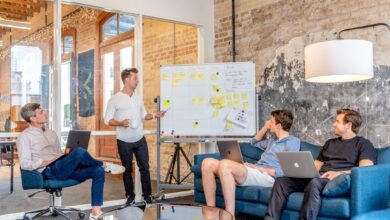 Como Cultivar Habilidades de Empreendedorismo Digital em Viagens - Web Nômade Digital three men sitting while using laptops and watching man beside whiteboard